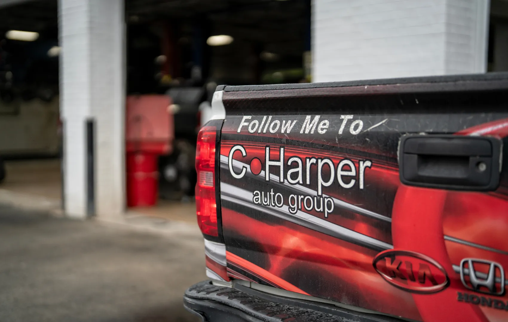 C. Harper branded red and black truck that says: "Follow Me To C. Harper auto group"